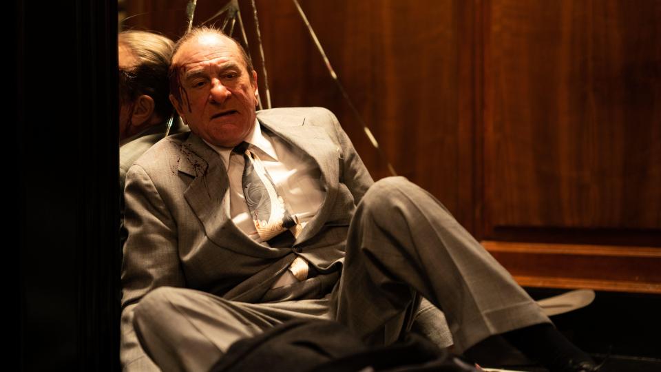 Robert De Niro as Frank Costello, injured and sitting in an elevator.