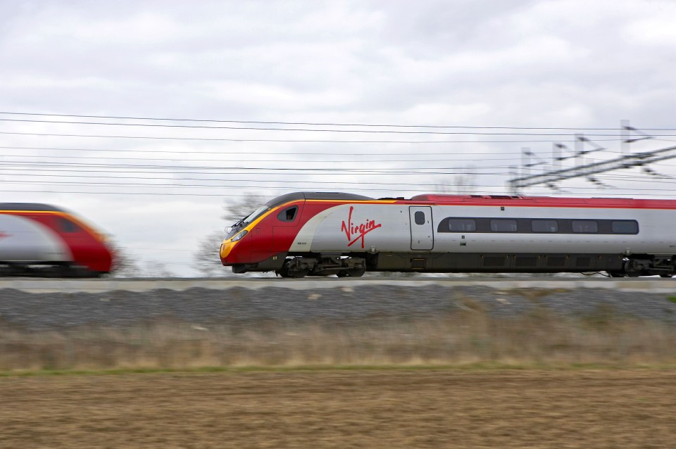 Two Virgin Pendolino trains speeding past each other.