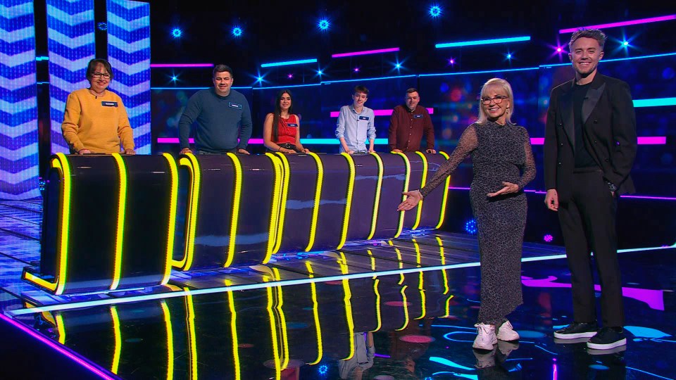 Contestants and hosts on a game show set.