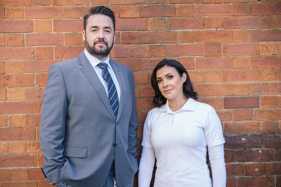 Jason Manford and Kym Marsh, Waterloo Road actors, posing against a brick wall.