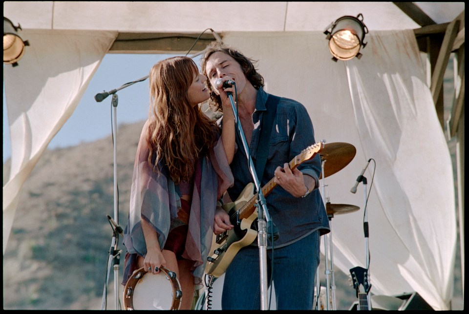 Riley Keough and Sam Claflin performing on stage.