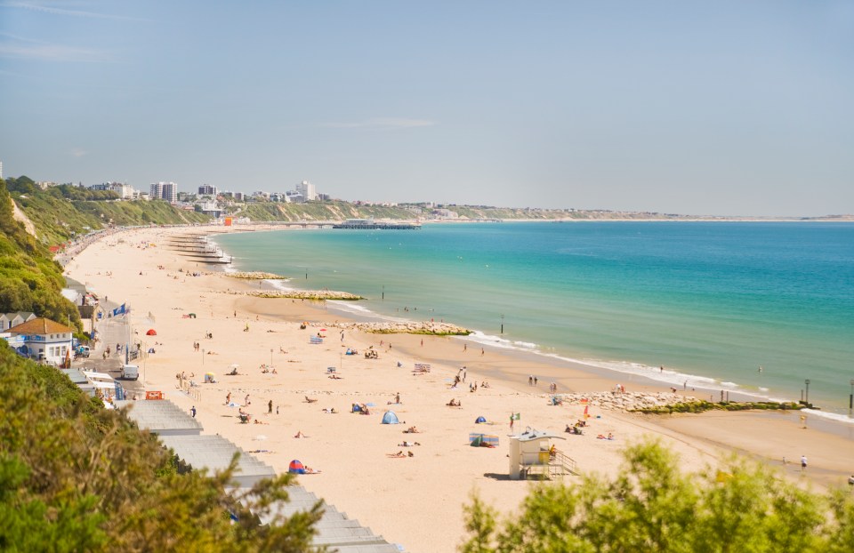 Bournemouth Beach in Dorset, England, with many people enjoying the sand and sea.