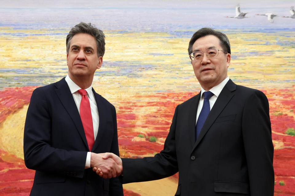Ed Miliband and Ding Xuexiang shaking hands.