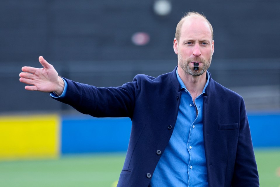 Prince William blowing a whistle at a football referee training course.