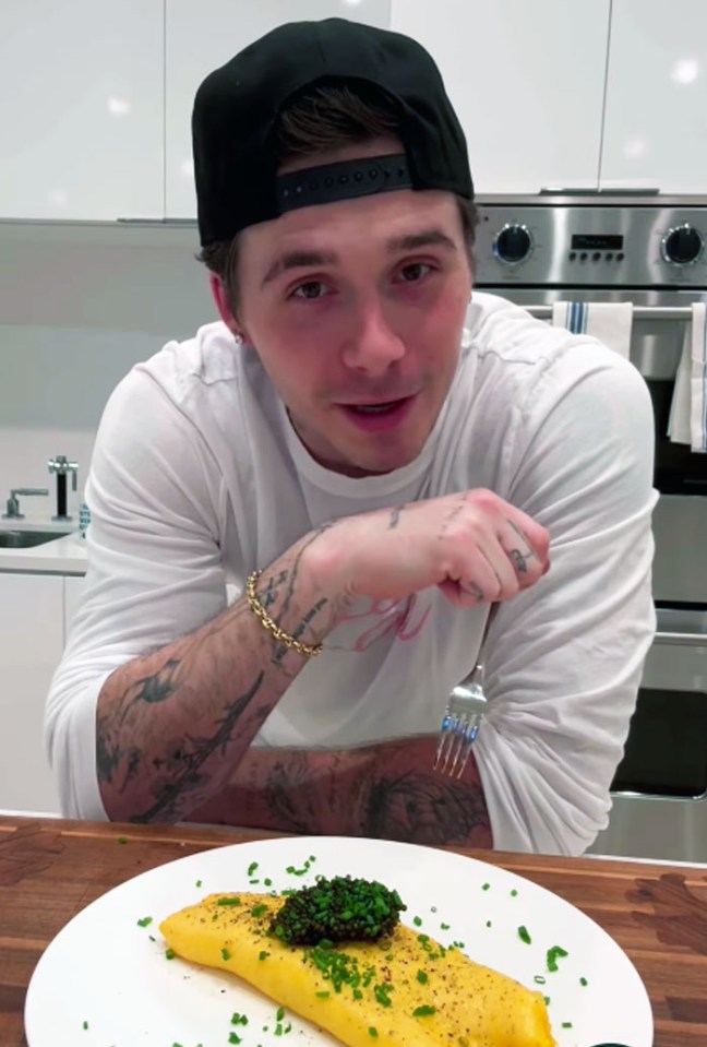 Man with tattoos making an omelette with caviar.