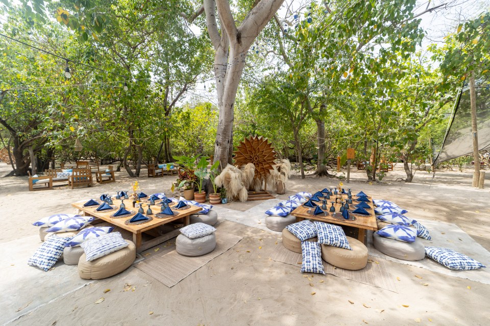 Two outdoor dining tables set for a meal on Corona Island.