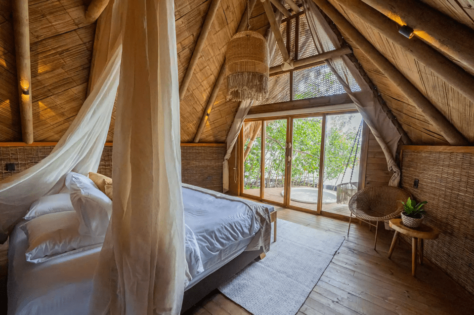 Bedroom with a four-poster bed and view of a patio.