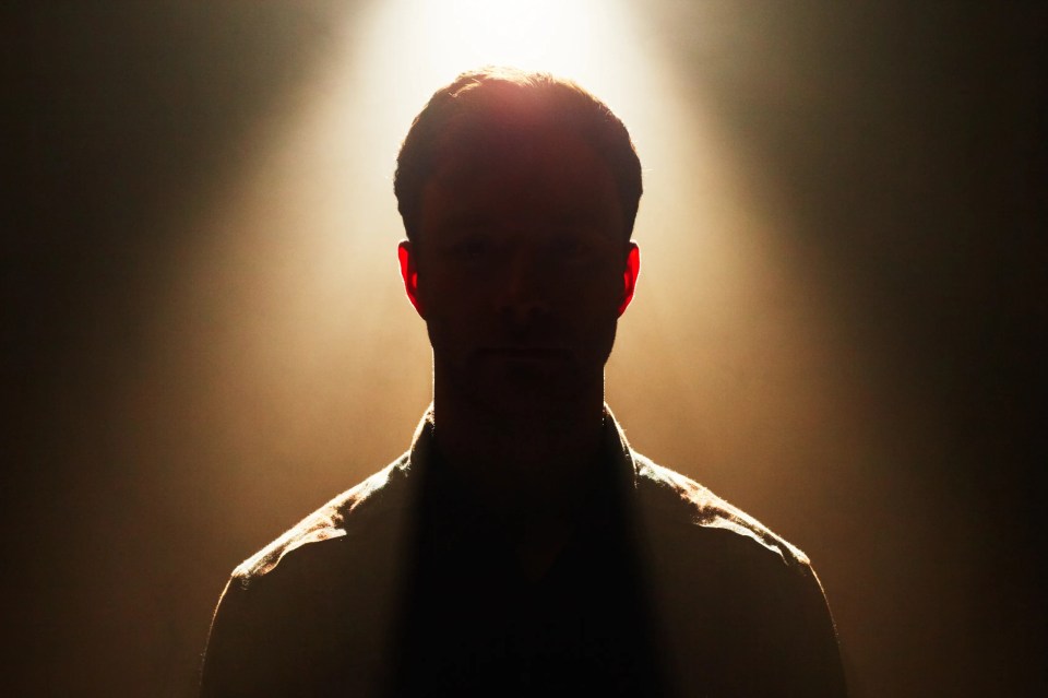a silhouette of a man in a dark room