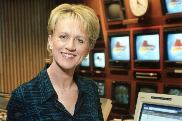 BBC presenter Sally Taylor holding files in a television studio.