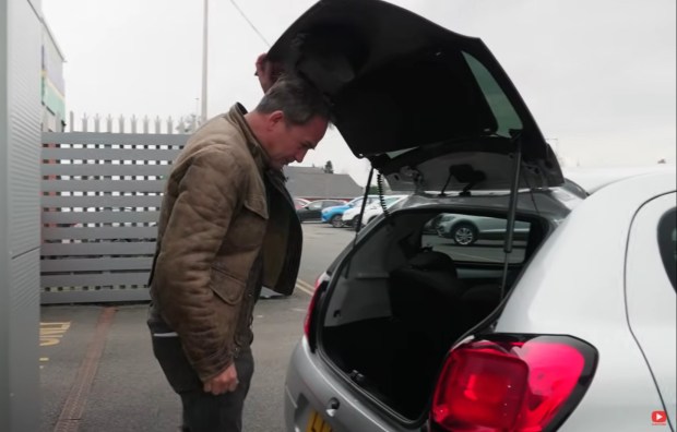 Man opening the trunk of a car.