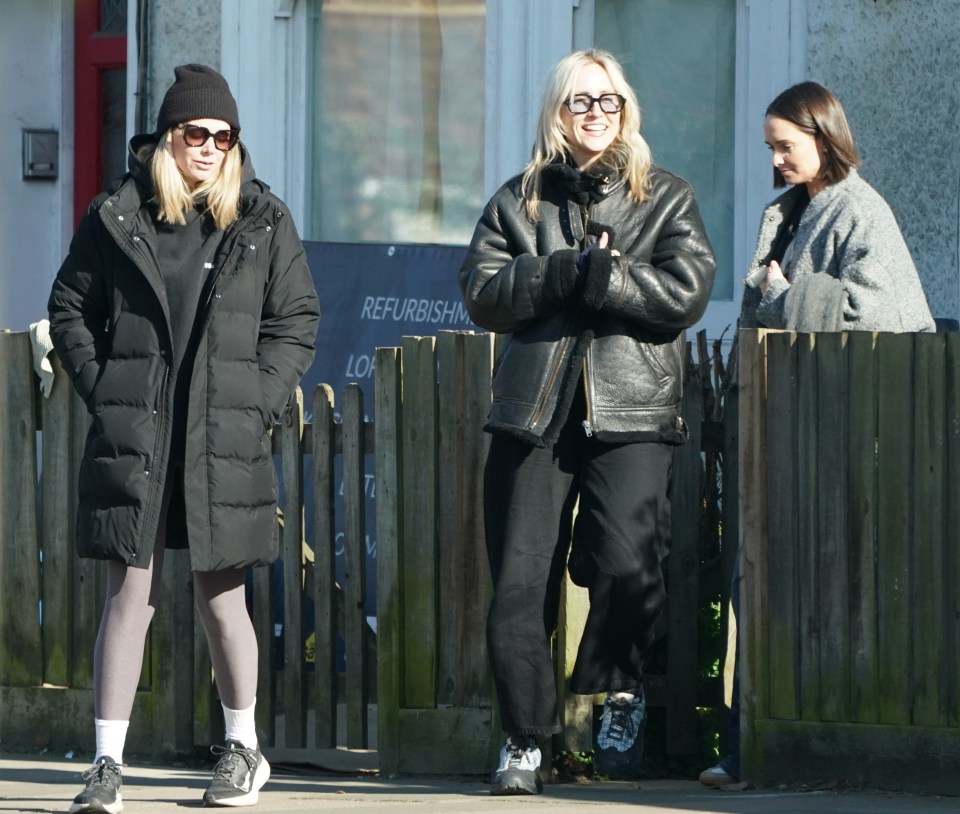 Three women standing outside a building.