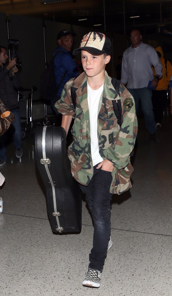 Cruz Beckham carrying a guitar case at LAX.