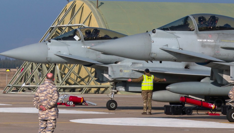 Two Eurofighter Typhoon jets on a military base.