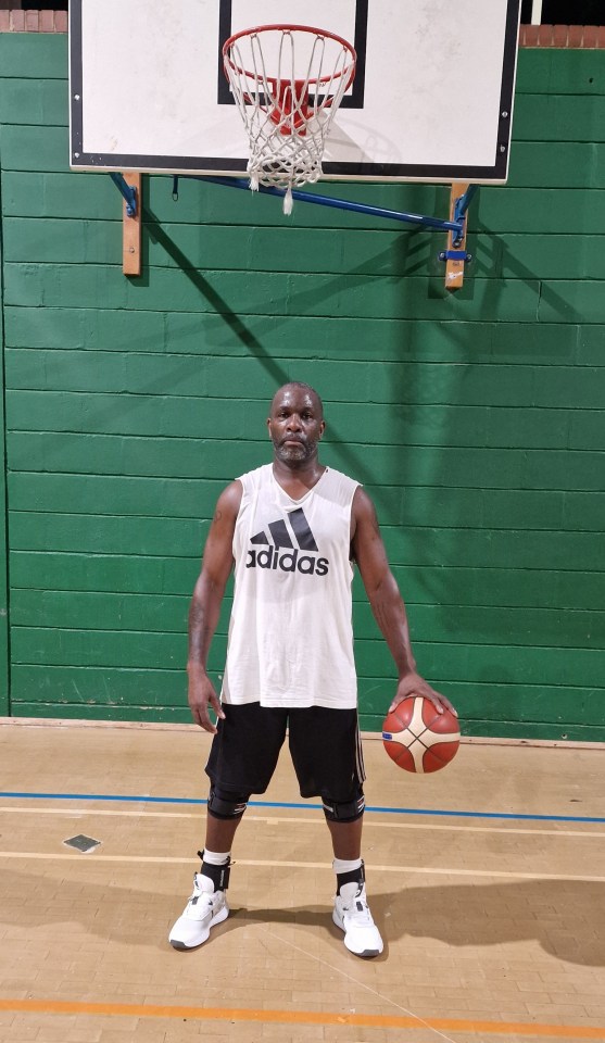 Man holding a basketball in a gym.