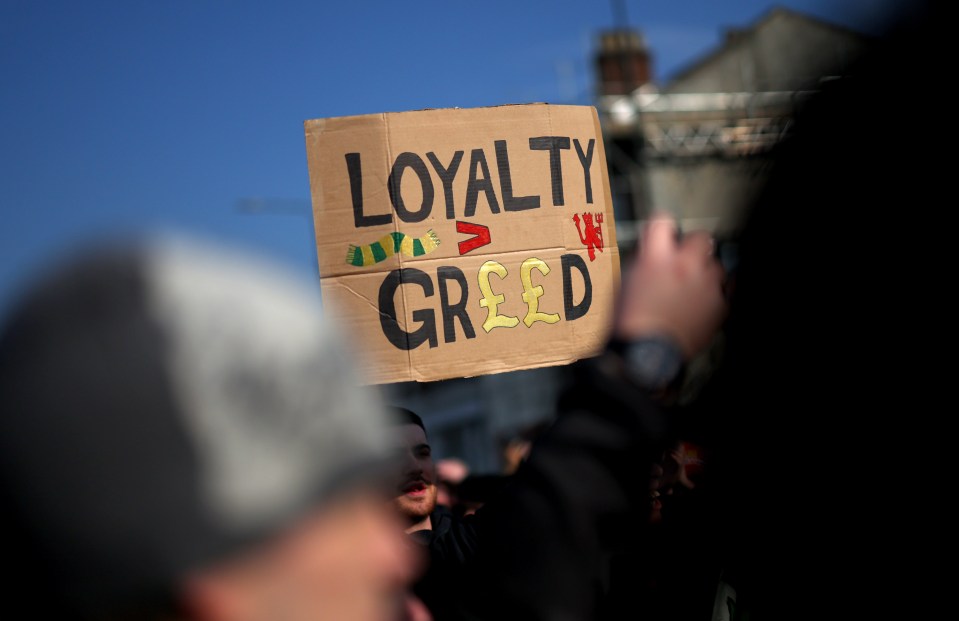 Protest sign reading "Loyalty > Greed".