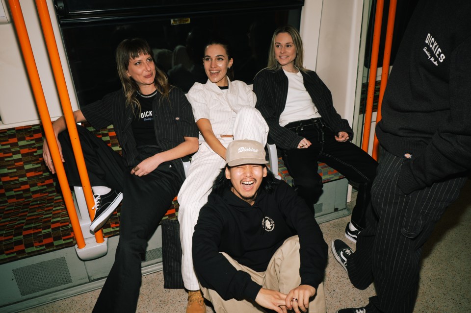 Group of young adults on a subway car wearing Dickies clothing.