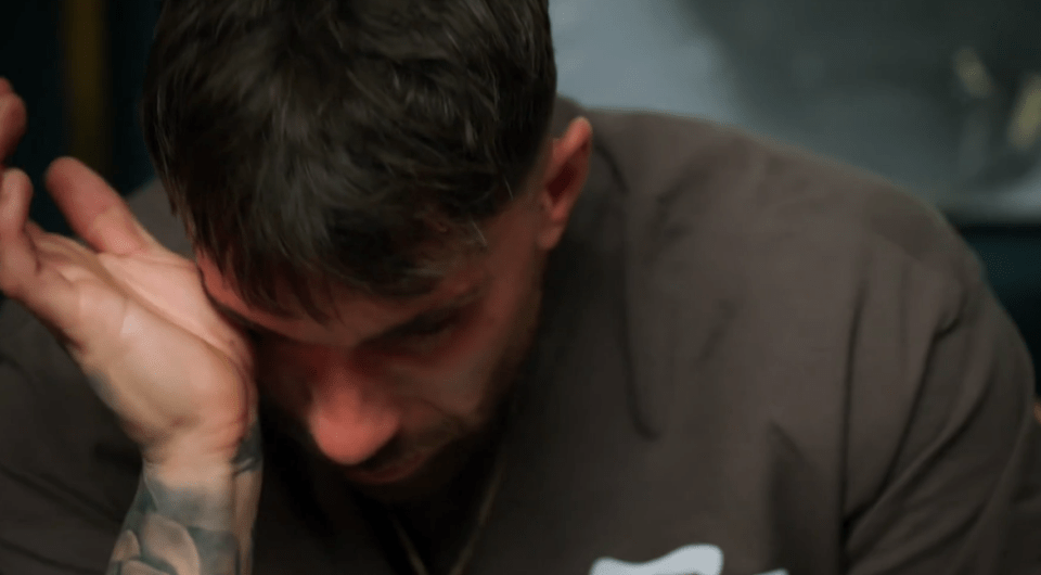 Man crying and wiping his eyes.