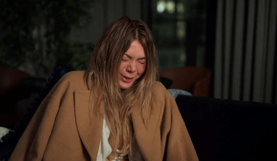 A woman crying on a couch.