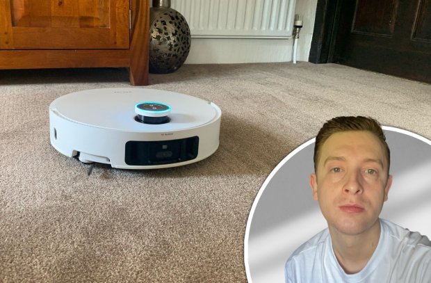A Dreame X50 Ultra robot vacuum cleaner on a carpet, next to a man.