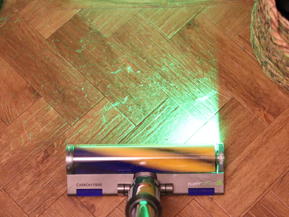 Dyson V15 Fluffy roller brush cleaning a wood floor.