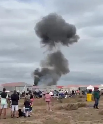 Smoke billowing from a plane crash at an air show.