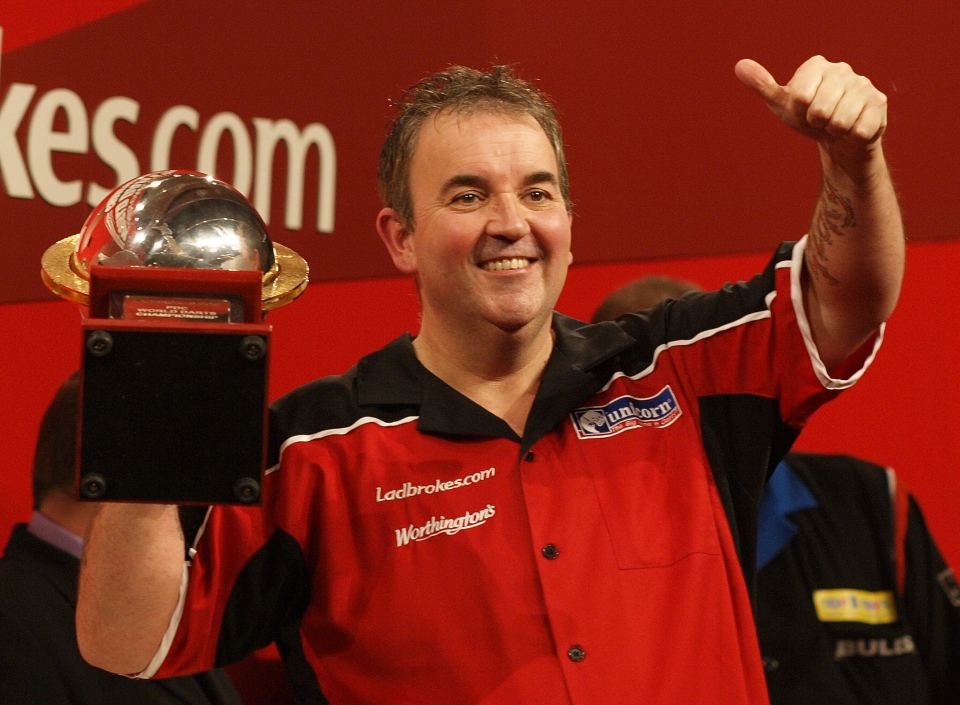 Phil Taylor holding the World Darts Championship trophy.