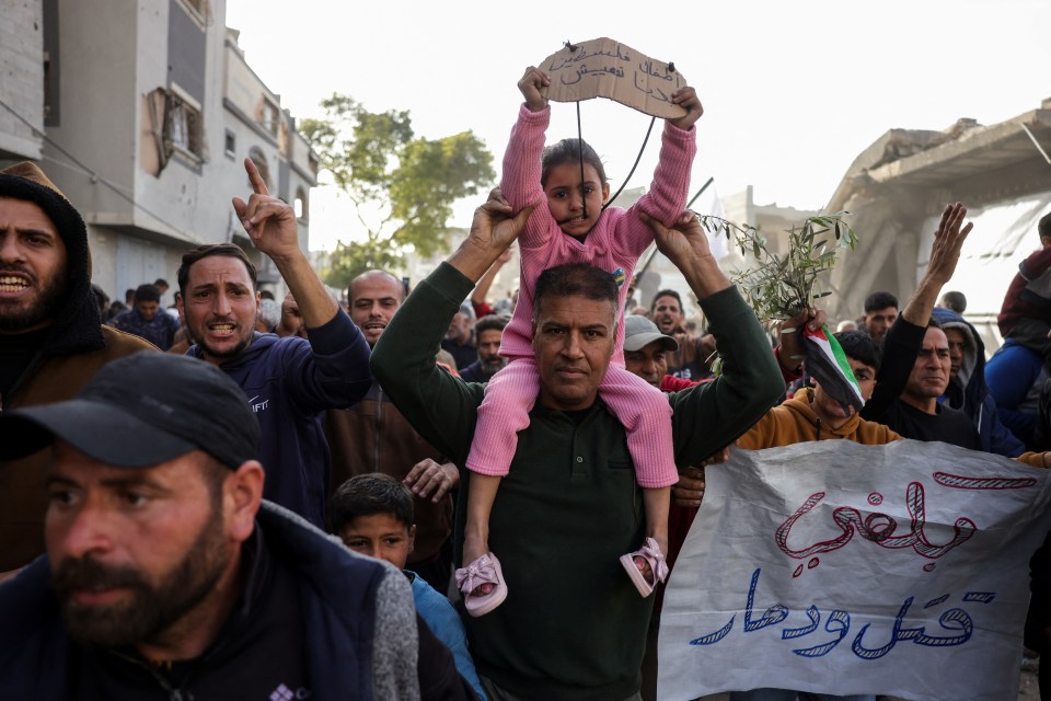 A Palestinian child holds a sign reading "Enough killing and destruction" at an anti-war rally in Gaza.