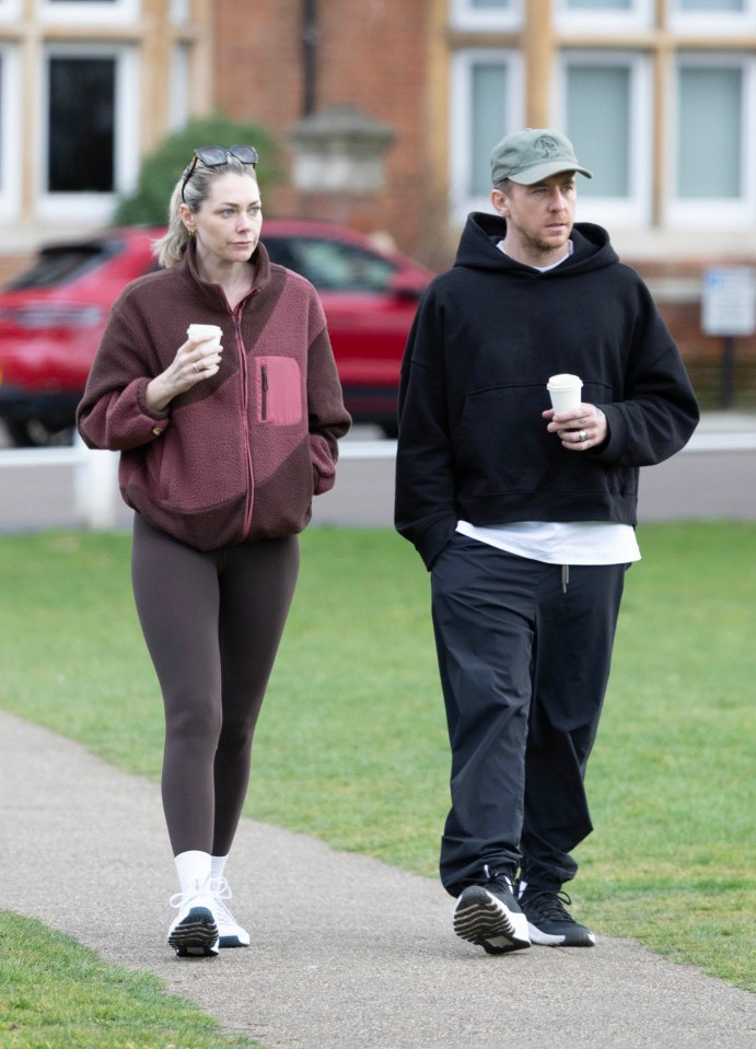 Danny and Georgia Jones walking and holding coffees.