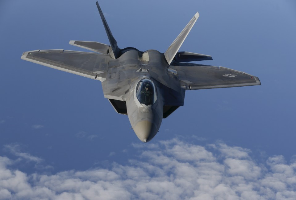 F-22 Raptor fighter jet in flight over clouds.