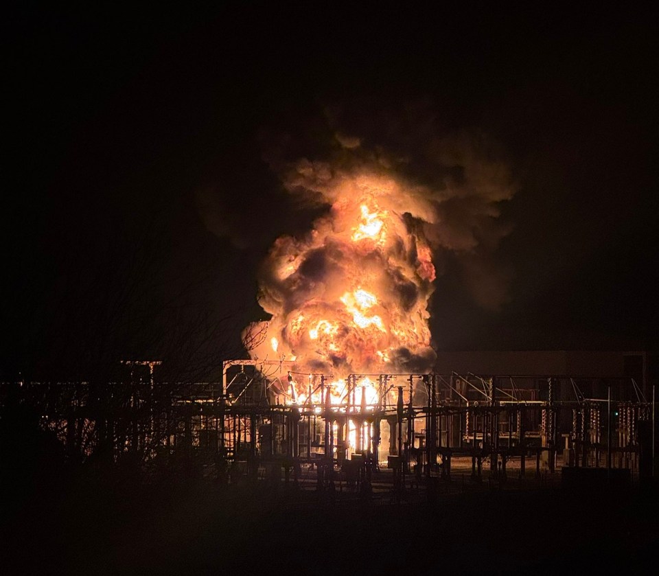 Large fire engulfing an electrical substation at night.