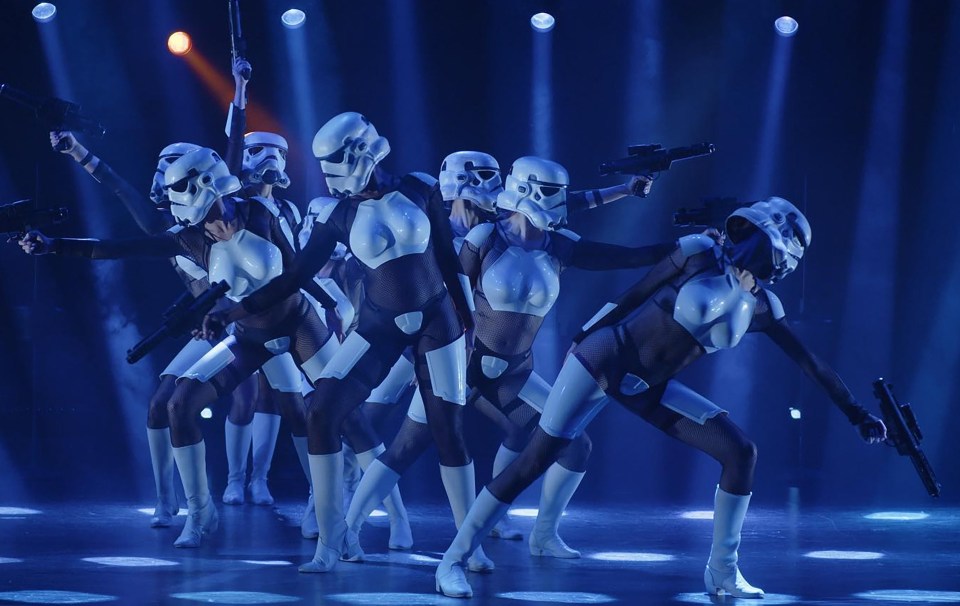 Dancers in Stormtrooper costumes performing on stage.