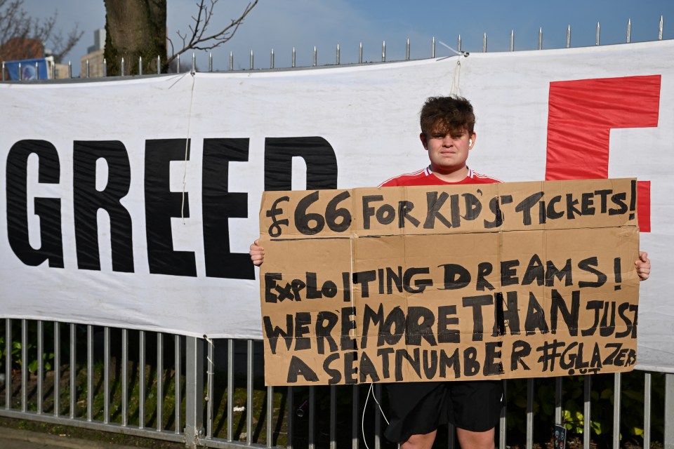 Protestor holding sign against high ticket prices and Manchester United ownership.