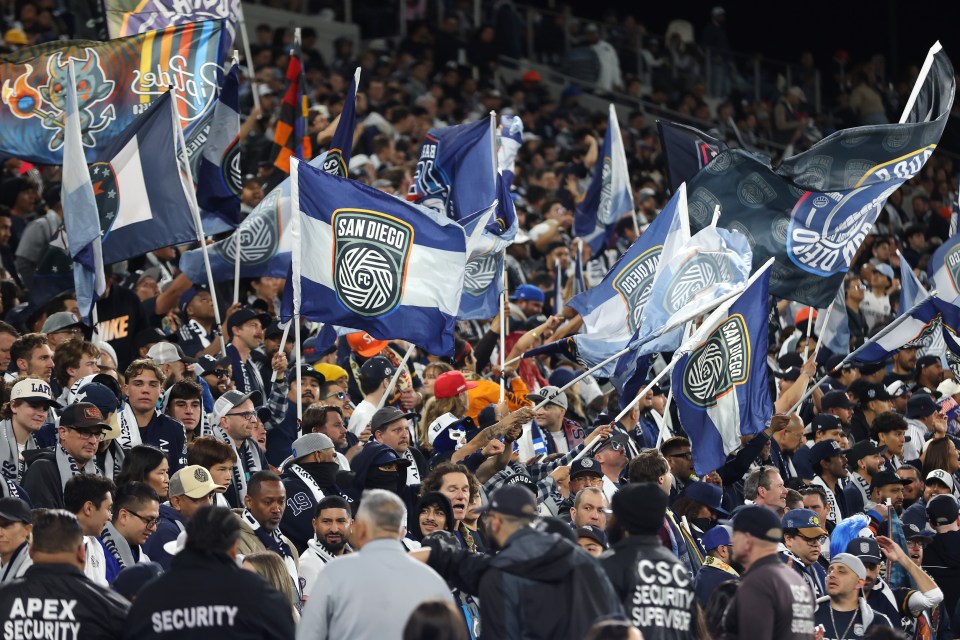San Diego FC fans waving flags at a soccer match.