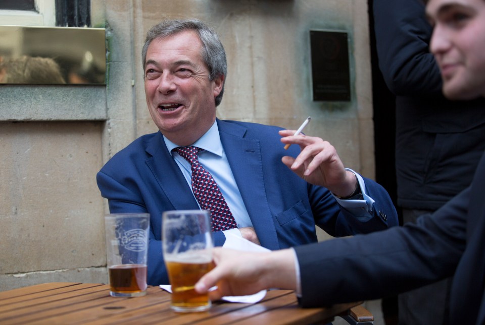 Nigel Farage in a pub, smoking a cigarette and drinking a pint.