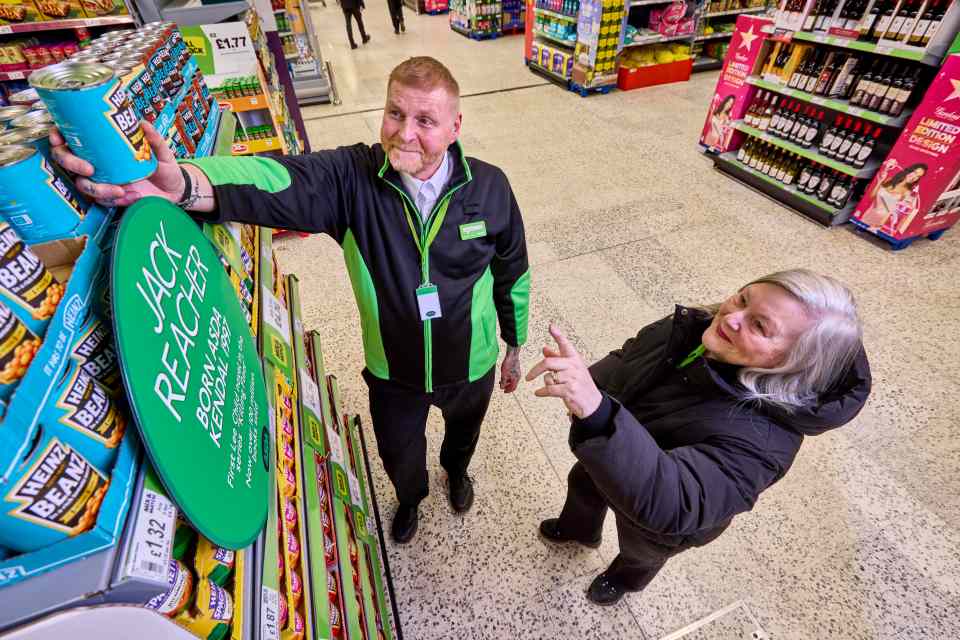 A photo of an ASDA Kendal employee and Lee Child's wife unveiling a plaque commemorating the supermarket as the inspiration for the Jack Reacher character.