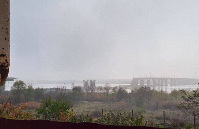 Distant view of a bridge and river in foggy conditions.