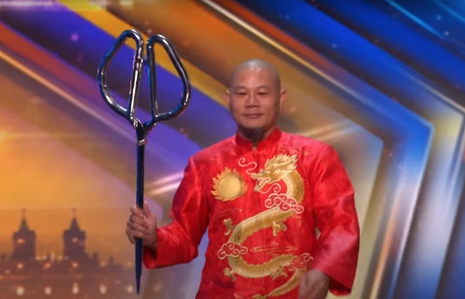 Man in red jacket holding a three-pronged metal object on Britain's Got Talent.