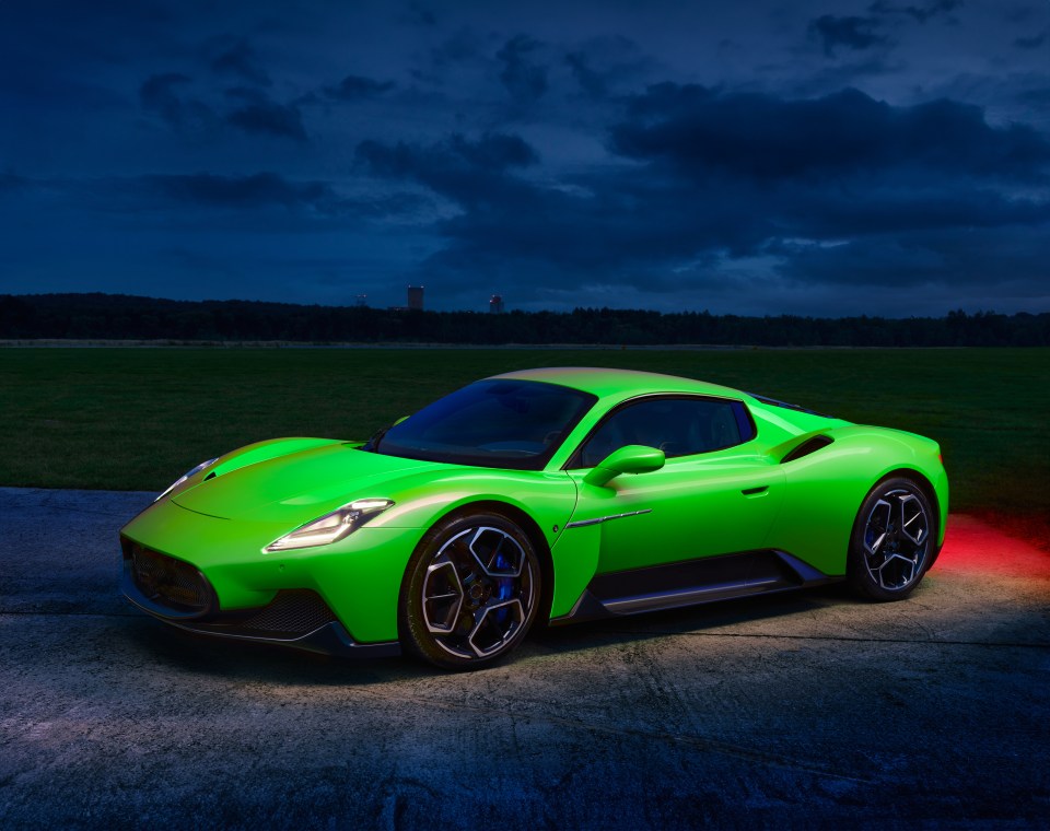 Green Maserati MC20 sports car at dusk.