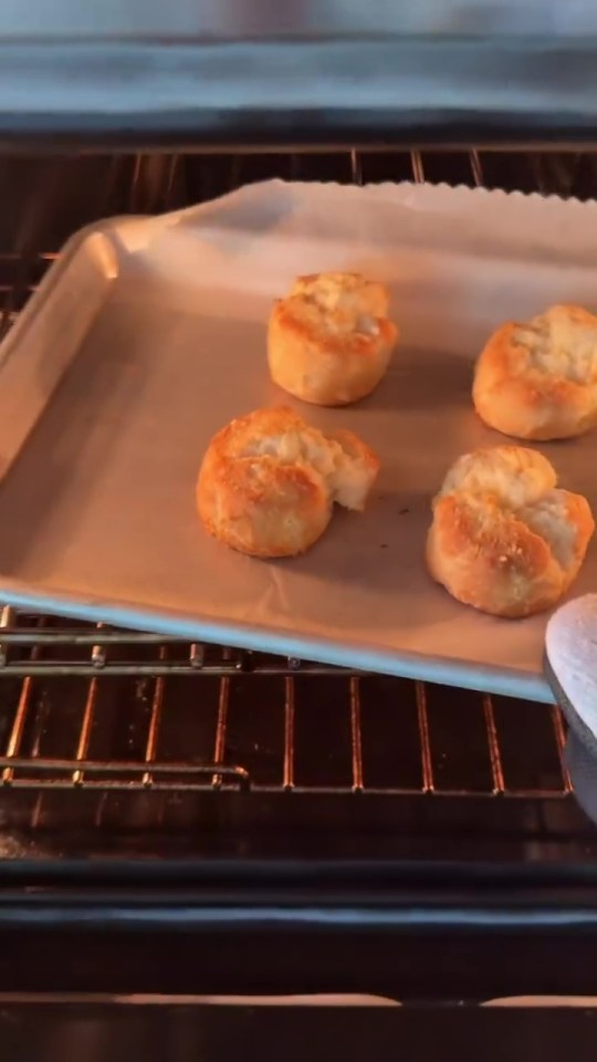 Baked biscuits on a baking sheet in an oven.