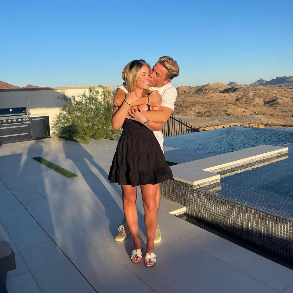 Couple embracing by a pool.