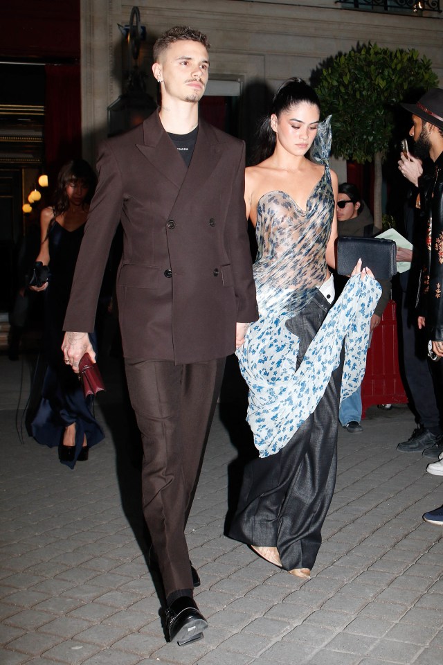 Romeo Beckham and a woman leaving a hotel during Paris Fashion Week.