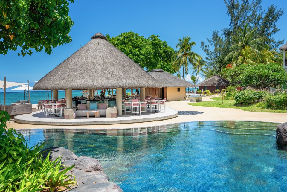 Resort pool bar with thatched roof huts.