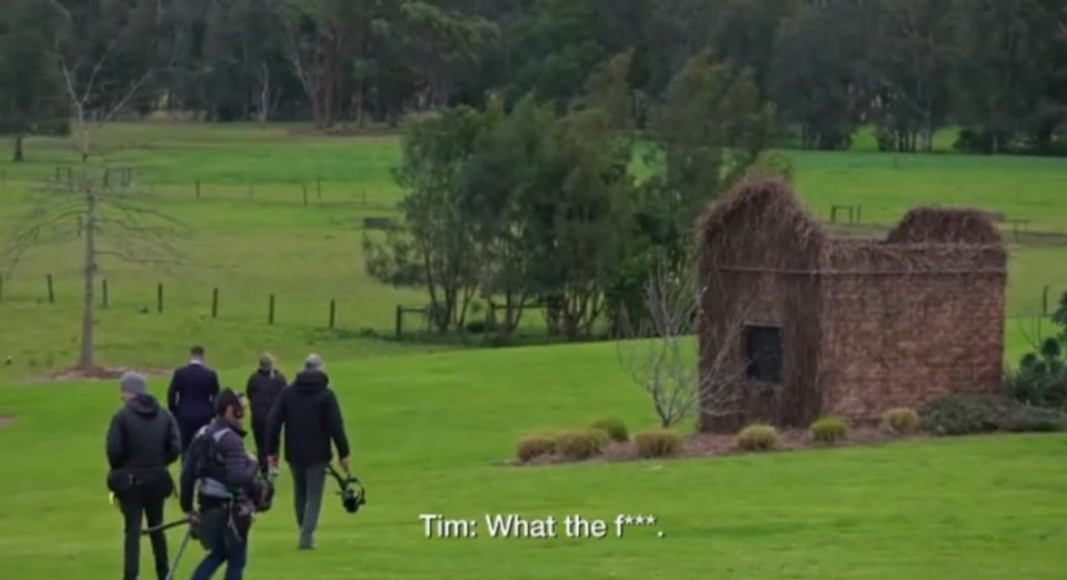 Film crew on a grassy field near a stone structure; caption reads "Tim: What the f***."