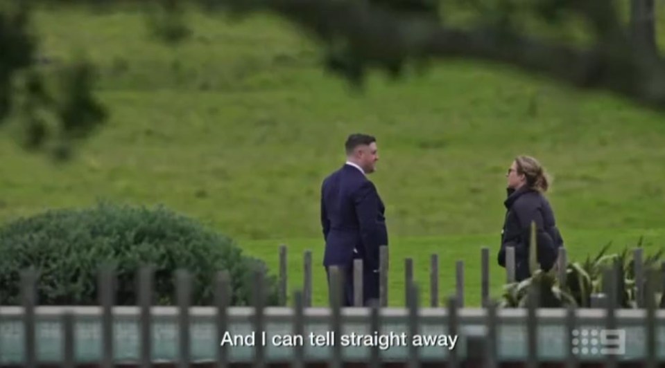 A man and woman standing outdoors, talking.
