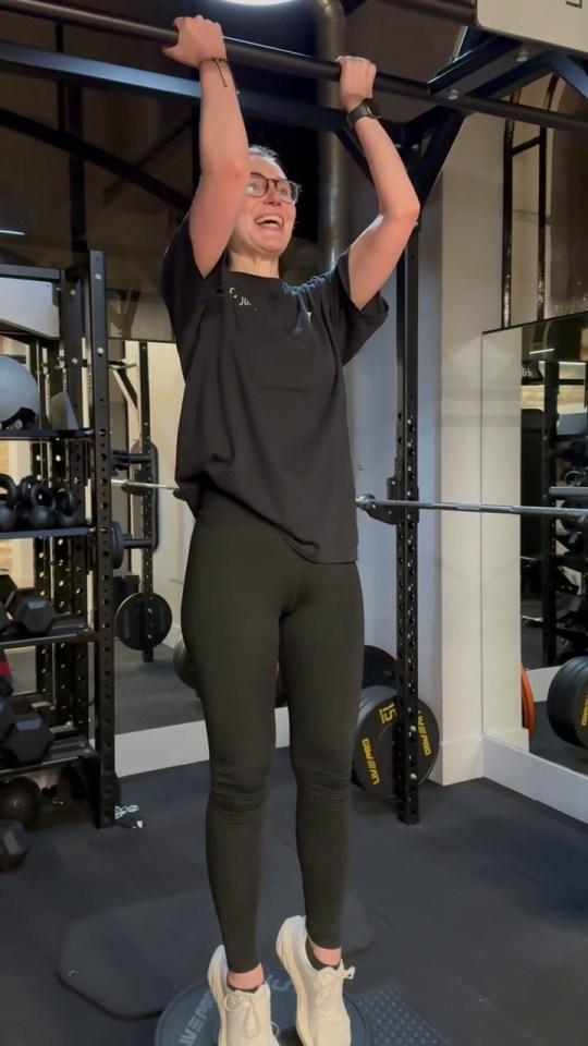 Woman doing pull-ups in a gym.