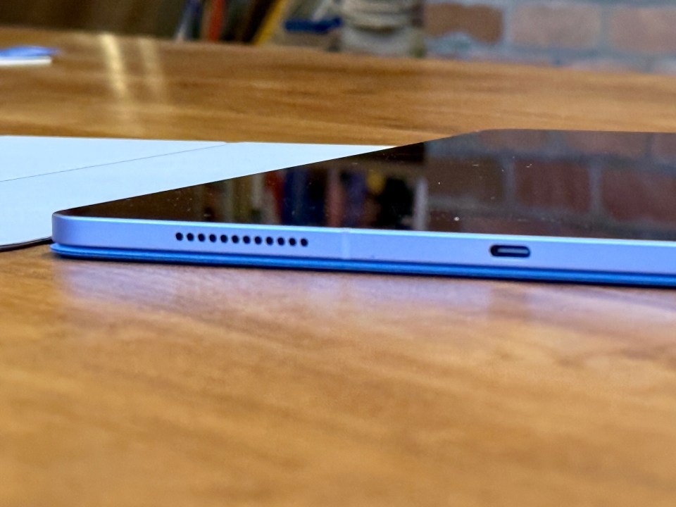 Close-up of a purple iPad Air's side, showing the speaker grill and USB-C port.