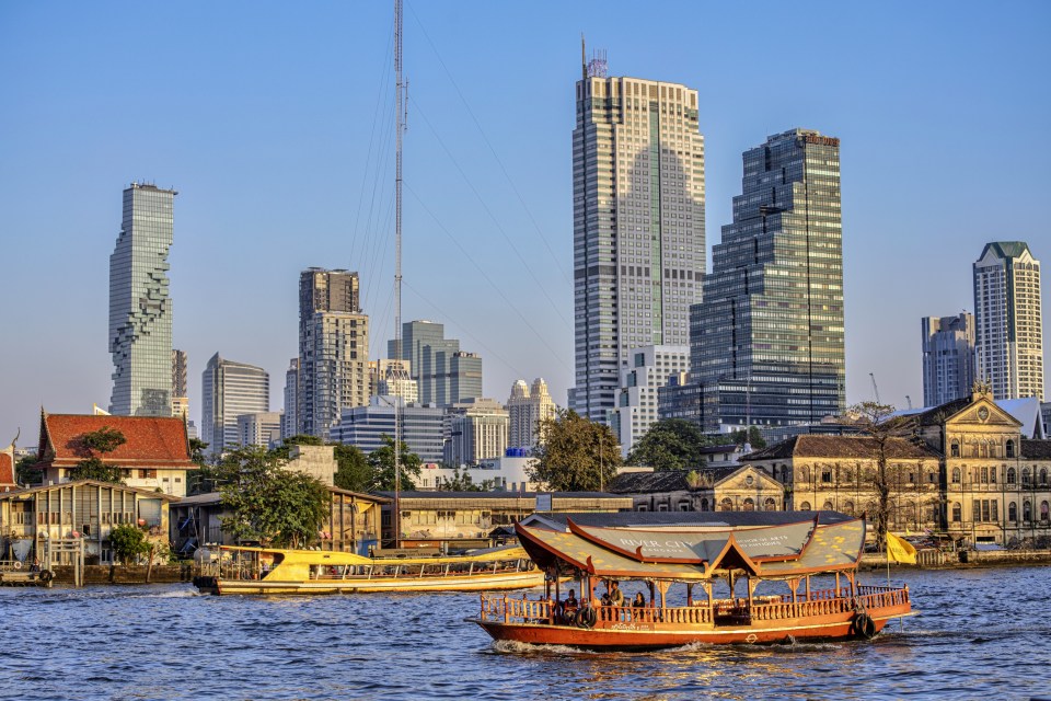Bangkok skyline with river boats.