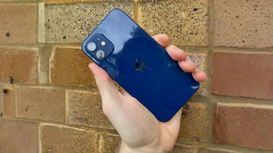 Refurbished blue iPhone 12 held in hand.