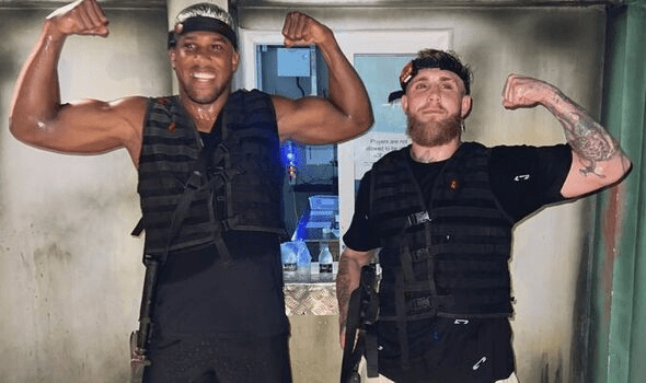 Two men in laser tag vests flexing their biceps.