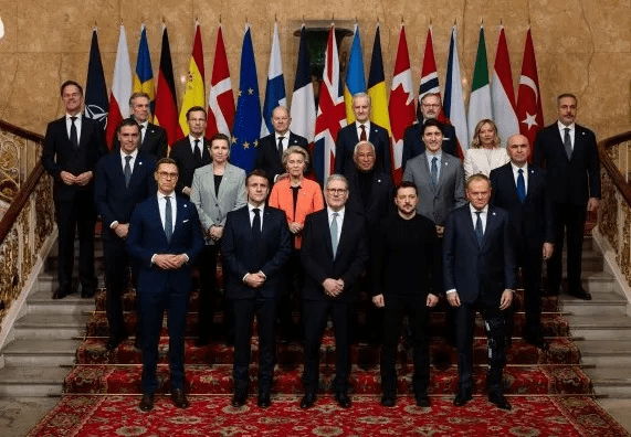 Group photo of world leaders standing on a staircase in front of their countries' flags.